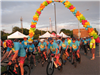 Bike riders begin the Tour de Belleville under a balloon archway 