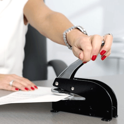 Notary Services Belleville Public Library: Hands stamping a document