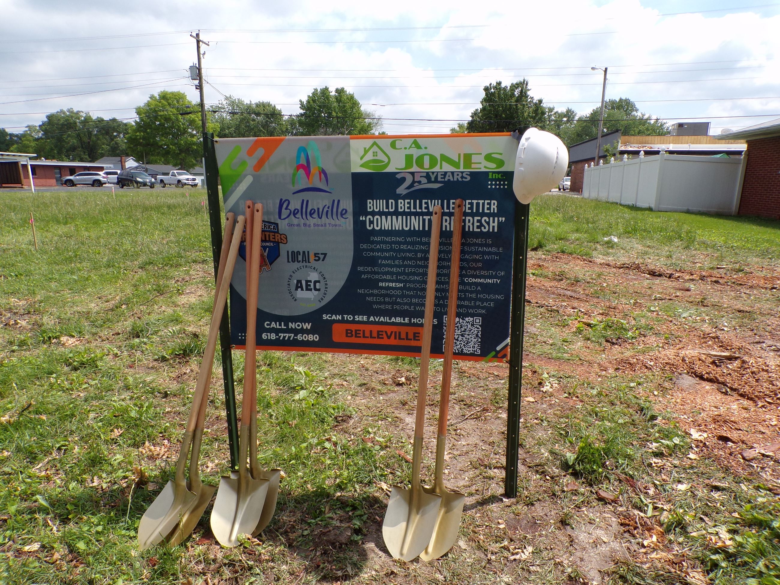 Gold shovels leaning against sign at vacant lot